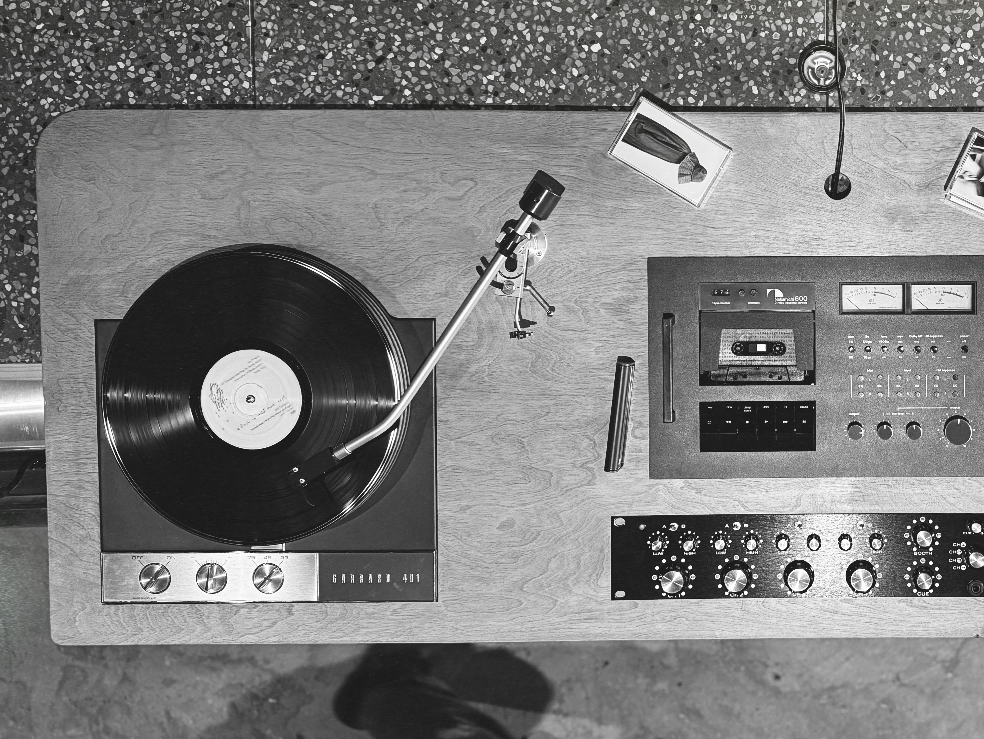 Overhead black-and-white view of a turntable and tape deck built into a wooden plinth.